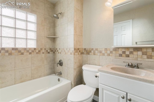 8230 Contrails Dr, Colorado Springs, CO 80920 - bathroom with vanity, toilet, shower / washtub combination, tile walls, and a textured wall