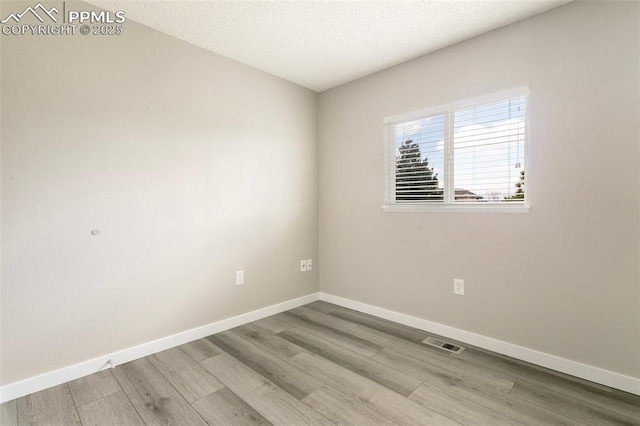 8230 Contrails Dr, Colorado Springs, CO 80920 - empty room with wood finished floors, baseboards, and a textured ceiling