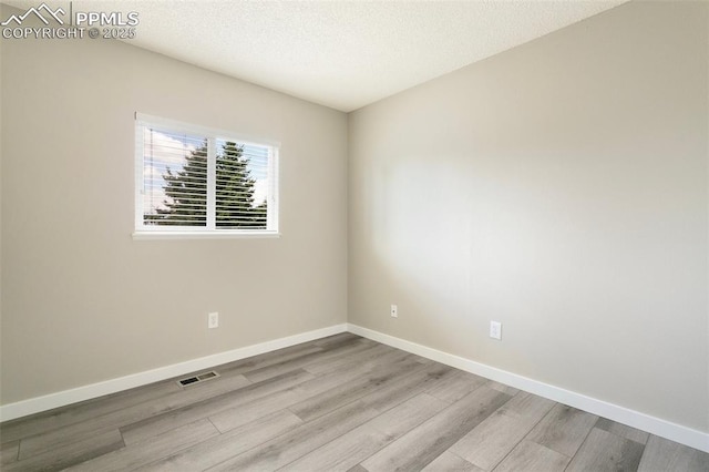 8230 Contrails Dr, Colorado Springs, CO 80920 - spare room featuring wood finished floors, baseboards, and a textured ceiling