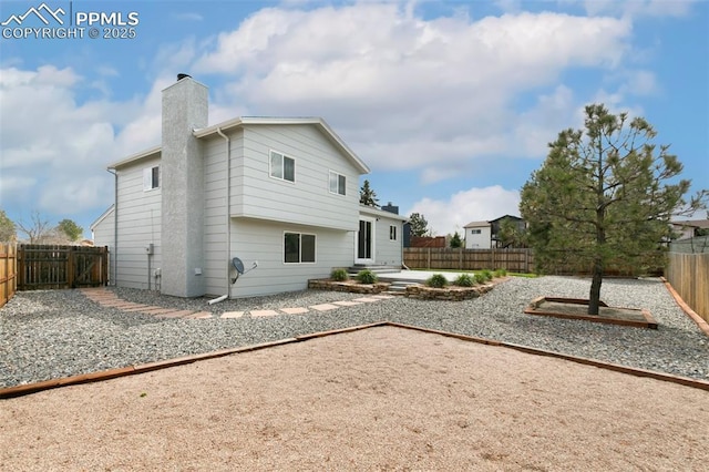 8230 Contrails Dr, Colorado Springs, CO 80920 - back of property with a fenced backyard, a chimney, and a patio