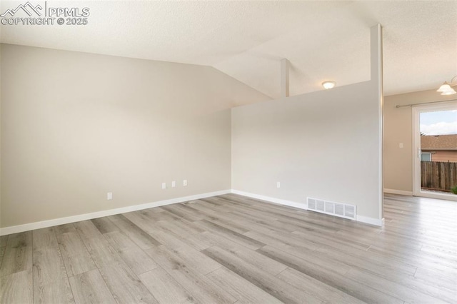 8230 Contrails Dr, Colorado Springs, CO 80920 - unfurnished room with light wood-style flooring, lofted ceiling, baseboards, and a textured ceiling