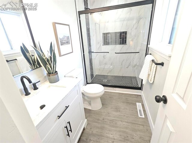 910 Dunston St, Colorado Springs, CO 80907 - bathroom featuring toilet, a marble finish shower, vanity, and wood finished floors
