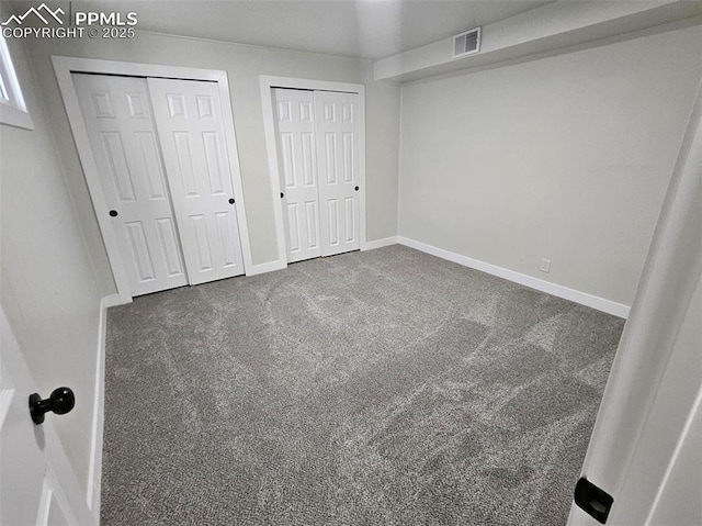 910 Dunston St, Colorado Springs, CO 80907 - unfurnished bedroom with two closets, carpet flooring, and baseboards