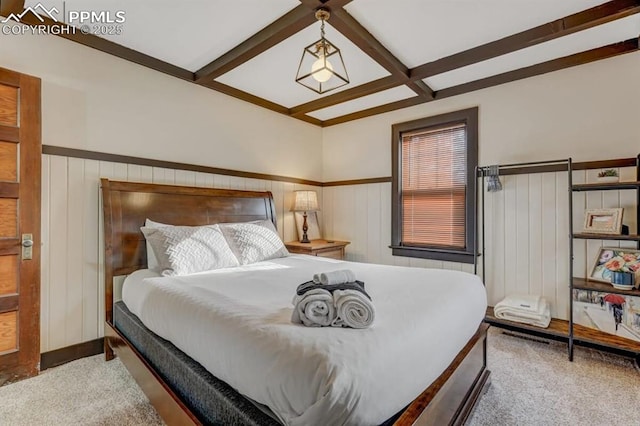bedroom with coffered ceiling, a wainscoted wall, beamed ceiling, and carpet flooring