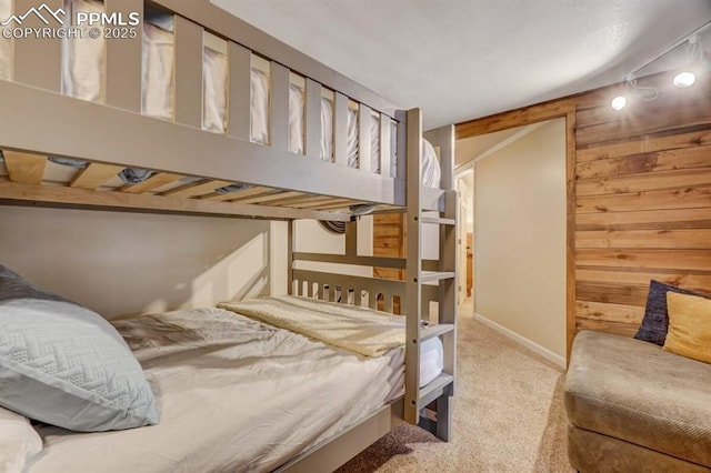 bedroom with wooden walls and carpet