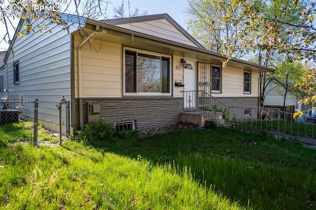 1701 Grant Ave, Colorado Springs, CO 80909 - view of front facade featuring stone siding and fence