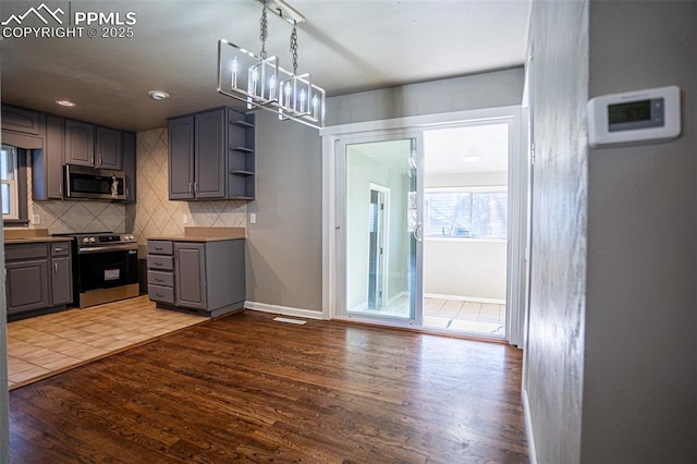 1701 Grant Ave, Colorado Springs, CO 80909 - kitchen featuring appliances with stainless steel finishes, gray cabinetry, tasteful backsplash, wood finished floors, and open shelves
