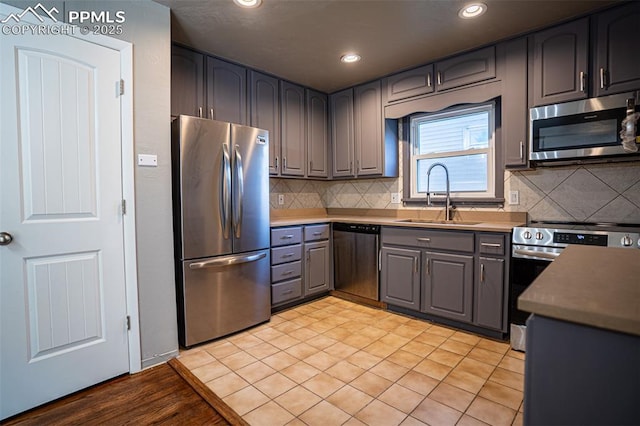 1701 Grant Ave, Colorado Springs, CO 80909 - kitchen featuring stainless steel appliances, a sink, gray cabinetry, backsplash, and recessed lighting
