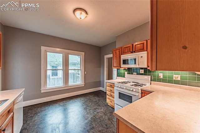 427 N Walnut St, Colorado Springs, CO 80907 - kitchen with white appliances, baseboards, light countertops, and brown cabinetry
