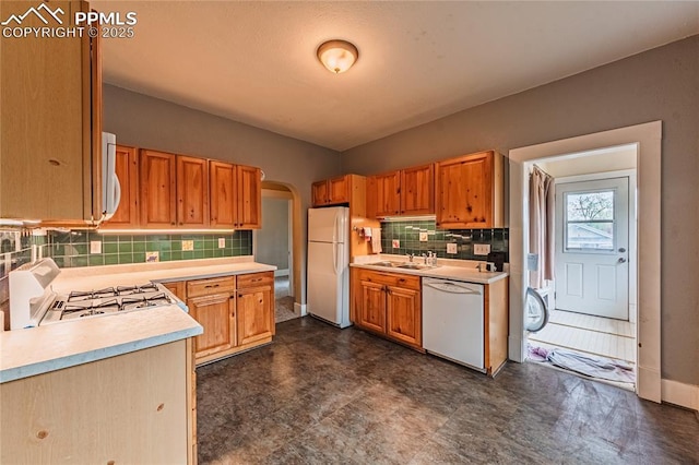 427 N Walnut St, Colorado Springs, CO 80907 - kitchen featuring white appliances, light countertops, backsplash, arched walkways, and dark floors