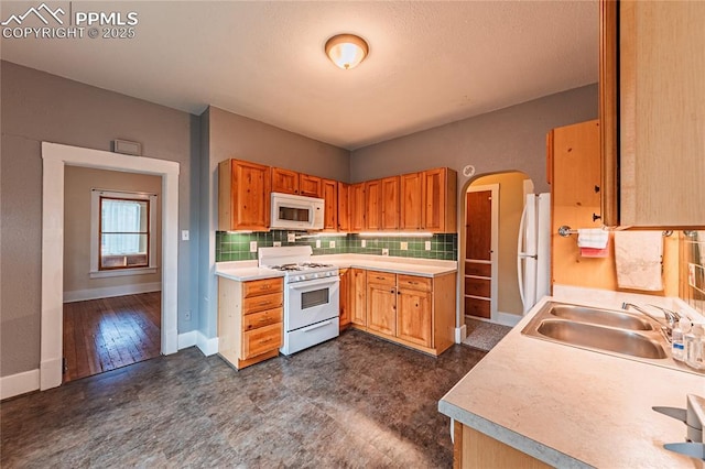 427 N Walnut St, Colorado Springs, CO 80907 - kitchen featuring white appliances, a sink, tasteful backsplash, light countertops, and baseboards