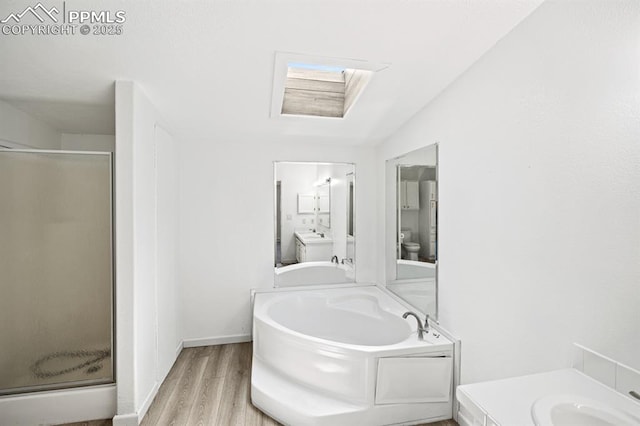 9775 Indian Village Hts, Fountain, CO 80817 - full bathroom featuring a skylight, wood finished floors, a shower stall, a bath, and vanity