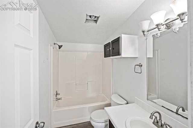 9775 Indian Village Hts, Fountain, CO 80817 - full bath with toilet, a textured ceiling, vanity, tub / shower combination, and vaulted ceiling