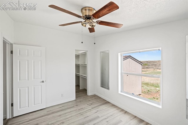 9775 Indian Village Hts, Fountain, CO 80817 - unfurnished bedroom featuring wood finished floors, a walk in closet, baseboards, a ceiling fan, and a closet
