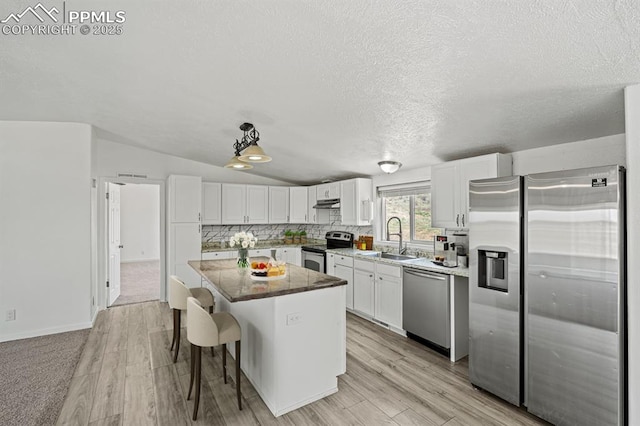 9775 Indian Village Hts, Fountain, CO 80817 - kitchen with appliances with stainless steel finishes, a sink, a center island, white cabinetry, and under cabinet range hood