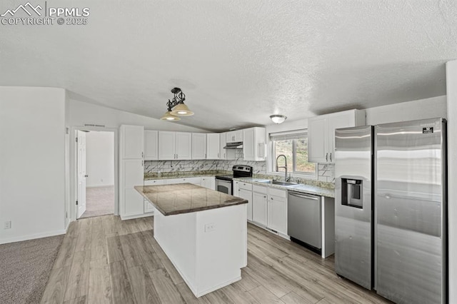 9775 Indian Village Hts, Fountain, CO 80817 - kitchen with appliances with stainless steel finishes, a sink, a kitchen island, white cabinetry, and under cabinet range hood
