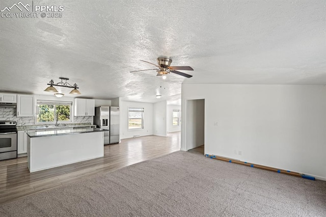 9775 Indian Village Hts, Fountain, CO 80817 - unfurnished living room featuring a ceiling fan, a textured ceiling, carpet, wood finished floors, and baseboards
