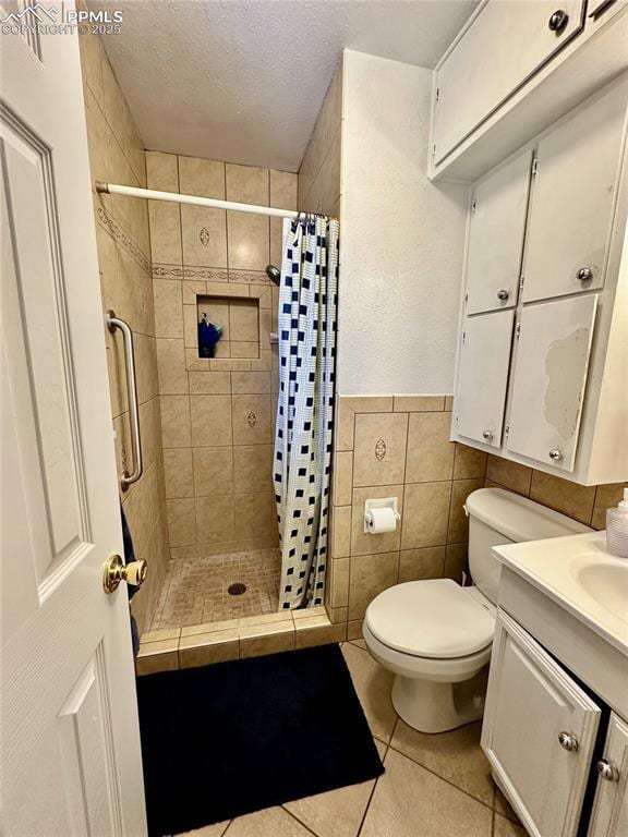 1701 Jerry Murphy Rd, Pueblo, CO 81001 - bathroom with tile patterned flooring, a shower stall, toilet, a textured ceiling, and tile walls