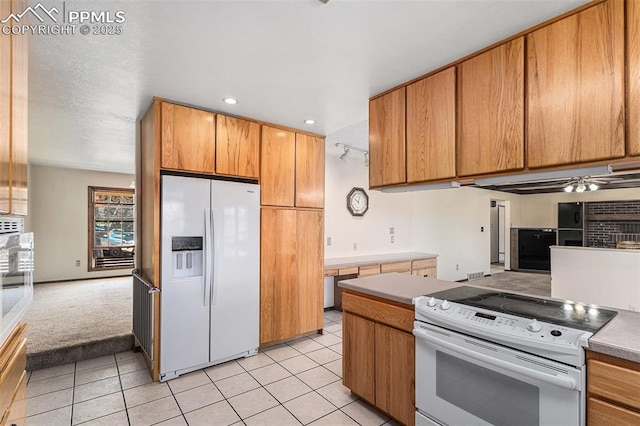 7210 Antelope Ln, Colorado Springs, CO 80920 - kitchen with white appliances, light tile patterned flooring, brown cabinetry, open floor plan, and recessed lighting