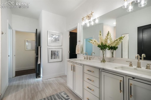 full bath featuring baseboards and double vanity