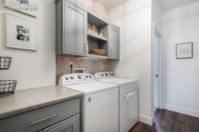 laundry room with cabinet space, dark wood-type flooring, washing machine and clothes dryer, and baseboards