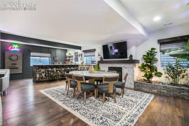 dining area featuring plenty of natural light, hardwood / wood-style floors, and a tiled fireplace