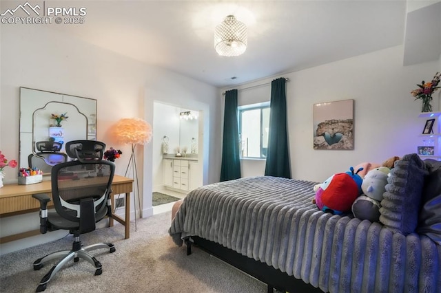 carpeted bedroom with an office area and connected bathroom