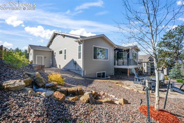 view of property exterior featuring a sunroom, stairway, and a patio