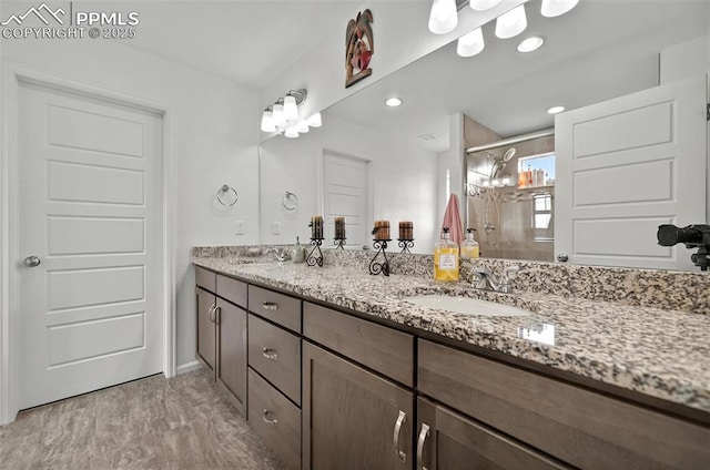 bathroom featuring a shower stall and double vanity
