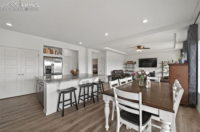 dining area with a ceiling fan, dark wood-style flooring, a raised ceiling, and recessed lighting