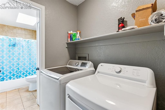 604 Blossom Field Rd, Fountain, CO 80817 - washroom featuring washing machine and clothes dryer, a textured wall, and light tile patterned floors
