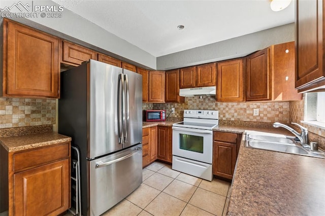 604 Blossom Field Rd, Fountain, CO 80817 - kitchen featuring white range with electric cooktop, freestanding refrigerator, a sink, under cabinet range hood, and light tile patterned flooring