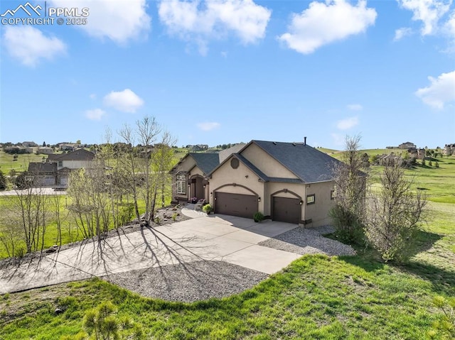 view of front of home with stucco siding, an attached garage, driveway, and a front yard