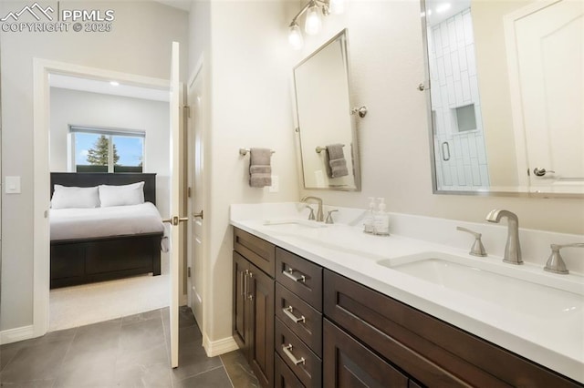 bathroom with double vanity, baseboards, a shower with shower door, and tile patterned flooring