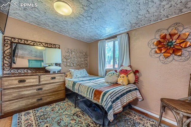 319 S Institute St, Colorado Springs, CO 80903 - bedroom with a textured wall, vaulted ceiling, a textured ceiling, and baseboards