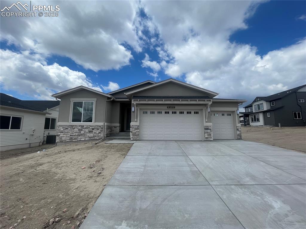 9392 S Gallery Pl, Colorado Springs, CO 80924 - ranch-style house with an attached garage, stone siding, driveway, and stucco siding