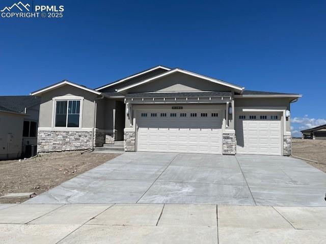9392 S Gallery Pl, Colorado Springs, CO 80924 - ranch-style home with stone siding, a garage, driveway, and stucco siding