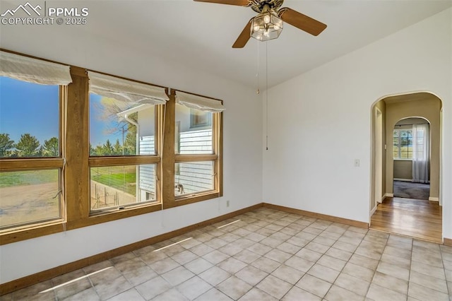 1475 S Peyton Hwy, Calhan, CO 80808 - empty room with arched walkways, baseboards, a ceiling fan, and light tile patterned floors