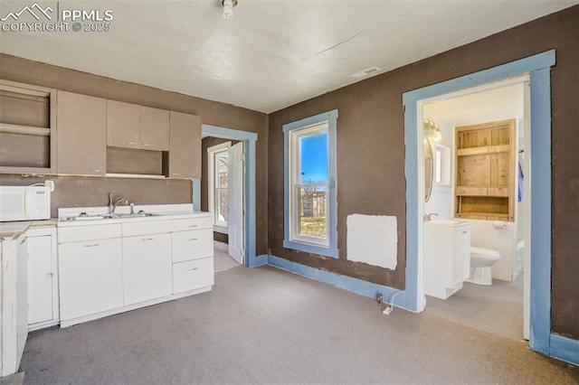1475 S Peyton Hwy, Calhan, CO 80808 - kitchen with a sink, white microwave, light countertops, and white cabinets