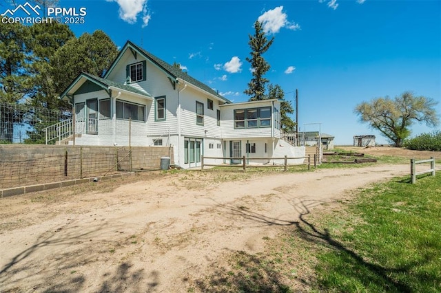 1475 S Peyton Hwy, Calhan, CO 80808 - rear view of house featuring a sunroom, fence, and driveway