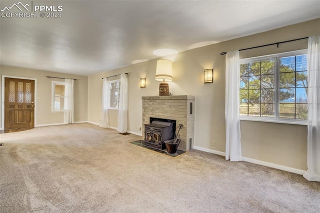 1475 S Peyton Hwy, Calhan, CO 80808 - unfurnished living room featuring a wood stove, baseboards, and carpet flooring