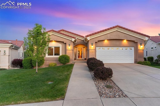2744 La Strada Grande Hts, Colorado Springs, CO 80906 - ranch-style house with driveway, a tile roof, a front yard, a garage, and stucco siding