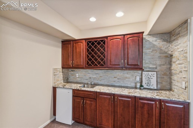 2744 La Strada Grande Hts, Colorado Springs, CO 80906 - indoor wet bar with tasteful backsplash, white dishwasher, carpet flooring, and baseboards