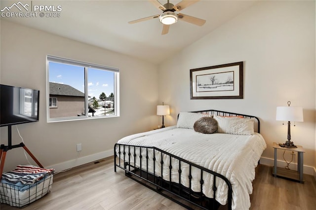 bedroom featuring baseboards, wood finished floors, lofted ceiling, and ceiling fan
