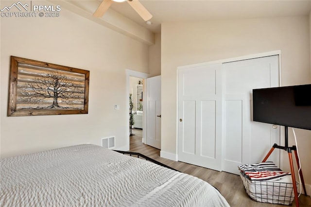 bedroom featuring wood finished floors, a closet, a ceiling fan, and high vaulted ceiling