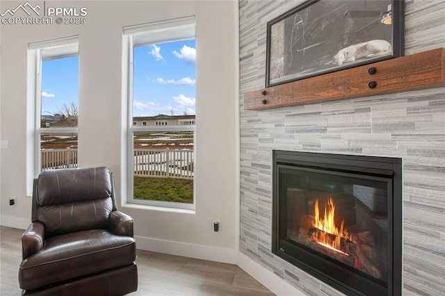sitting room with baseboards, wood finished floors, and a fireplace