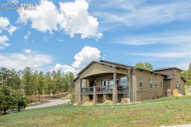 back of property featuring stucco siding and a lawn