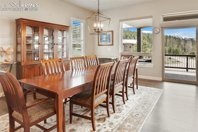 dining room with a chandelier, wood finished floors, and baseboards
