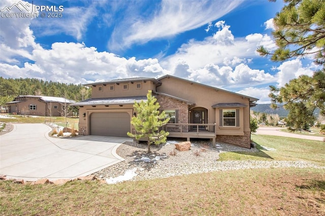 mediterranean / spanish house with concrete driveway, a front yard, a garage, stone siding, and stucco siding