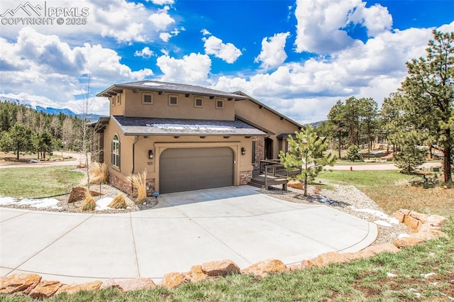 view of front of property featuring stucco siding, stone siding, driveway, a garage, and a front lawn